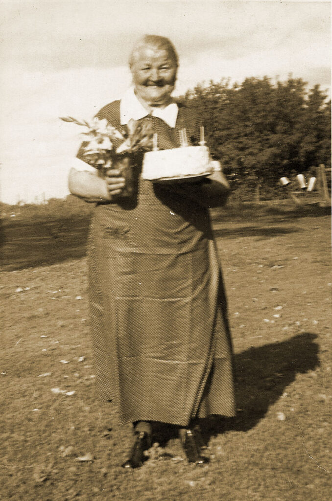 Anna Dahl holding flowers and birthday cake with candles